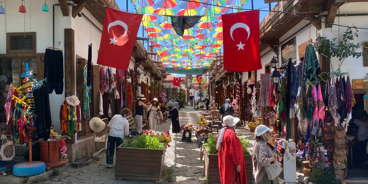 Renkli şemsiyeler ve Türk bayrakları altında, el emeği ürünlerin sergilendiği Hüma Hatun Sokağı, Divriği