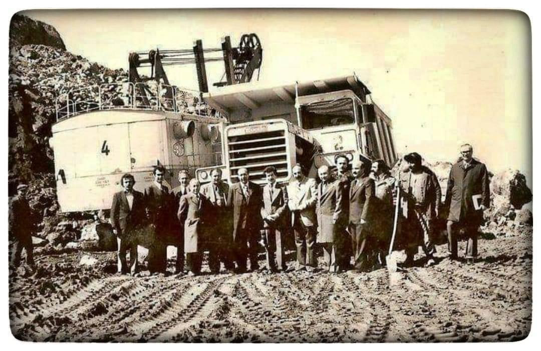 Bir makinenin yanında duran insanlar
