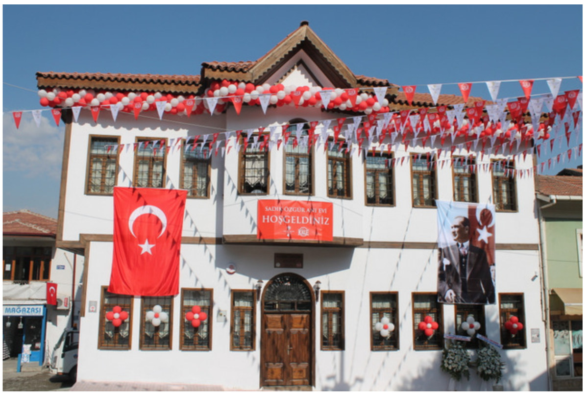 Sadık Özgür Anı Evi’nin bayraklar ve açılış süsleriyle görünen dış cephesi