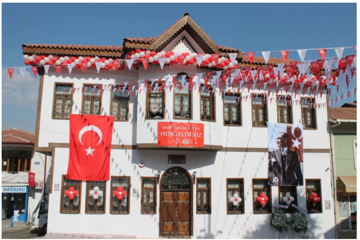 Exterior of the Sadık Özgür Memorial House with flags and opening decorations